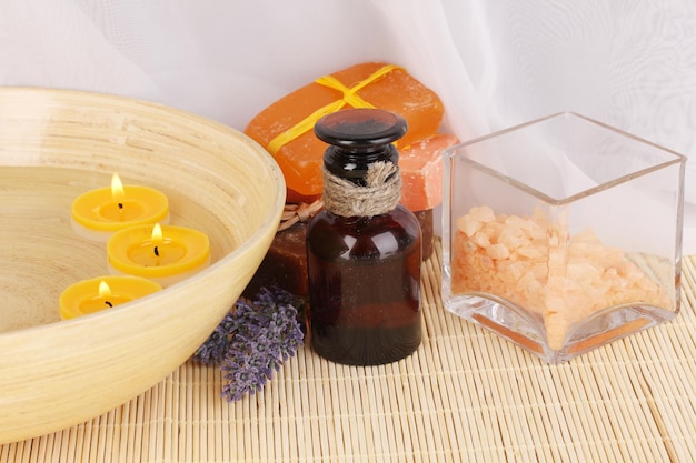 Bottle with aromatic oils with accessories for relaxation on wooden table on wooden background