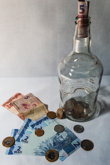 Bottle with coins and real banknote