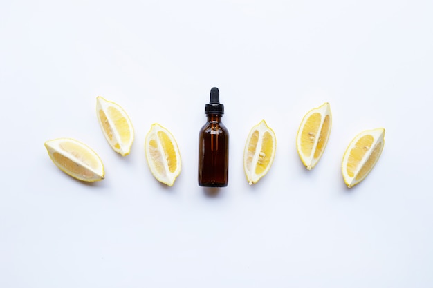 Bottle with lemon essential oil on white