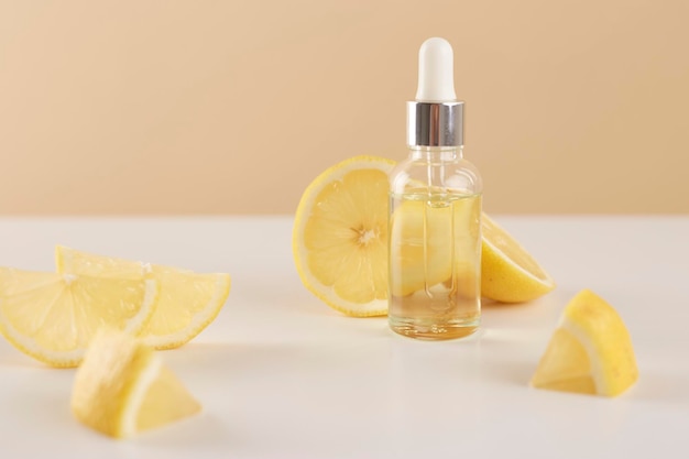 Bottle with lemon essential oil with lemon slices on table Cosmetic citrus oil or serum Natural medicine concept Aromatherapy