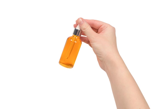 Bottle with oil in woman hand isolated on white. Copy space.