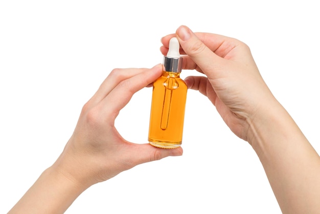 Bottle with oil in woman hand isolated on white. Copy space.