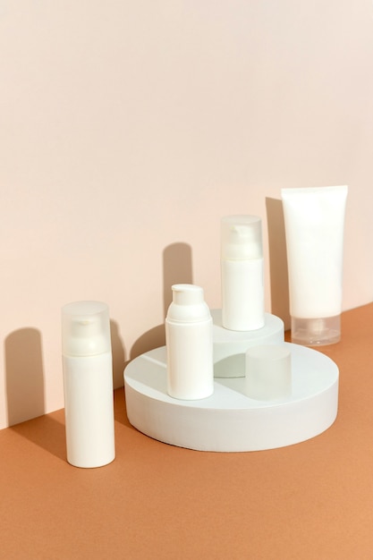 Bottles of cosmetic cream on podium in sunlight. Minimal style cosmetics template