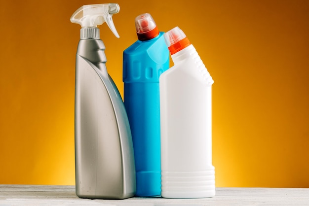 Bottles of detergent and cleaning products on a yellow background.