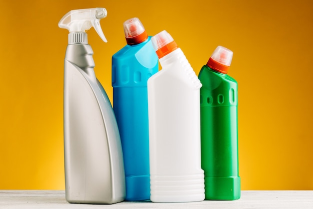 Bottles of detergent and cleaning products on a yellow background.