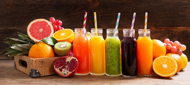 Bottles of fruit juice with fresh fruits