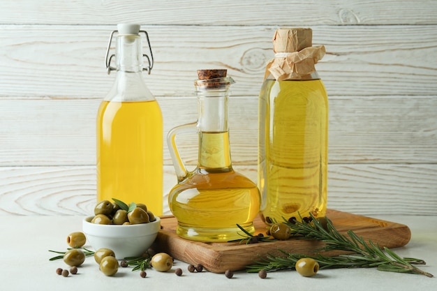 Bottles of olive oil against white wooden