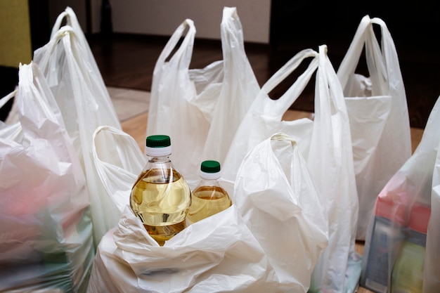 Bottles of vegetable oil and many bags are on the floor