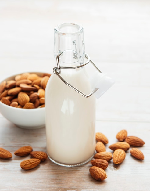 Bottles with almond milk and almonds on the table