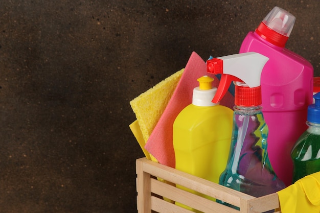 Bottles with cleansers and cleaning tools in a drawer on a brown background. cleaning. cleaning products. place for text. free place. close-up