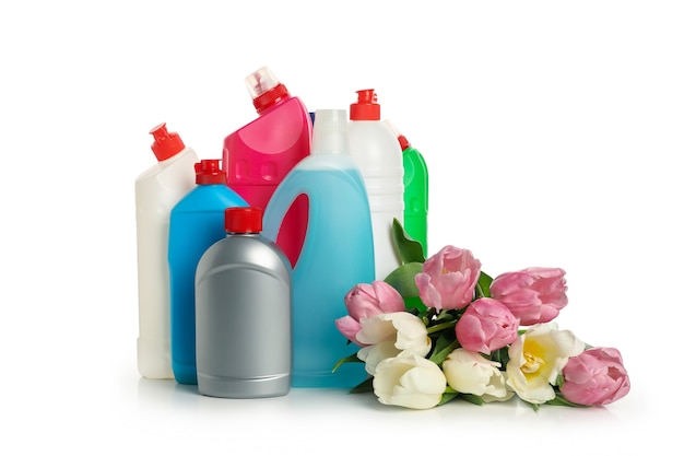 Bottles with detergent and tulips on white