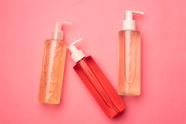 Bottles with gel for washing on a pink background Care cosmetics Copy space Article about the choice of gel for washing