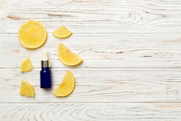 Bottles with lemon fruit essential oil on wooden background alternative medicine top view with copy space