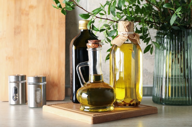 Bottles with oil and plant on kitchen table