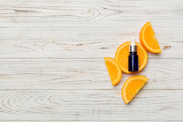 Bottles with orange fruit essential oil on wooden background alternative medicine top view with copy space