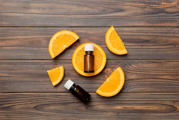 Bottles with orange fruit essential oil on wooden background alternative medicine top view with copy space