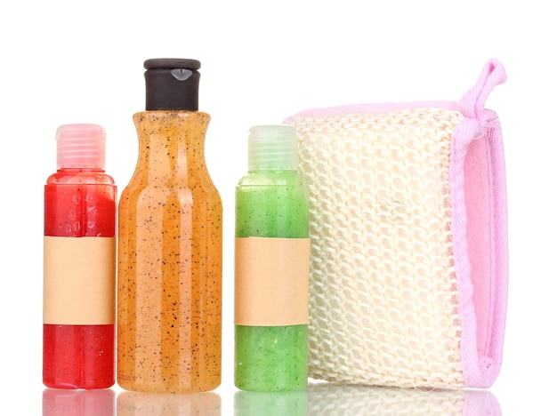 Bottles with scrub and sponge isolated on white