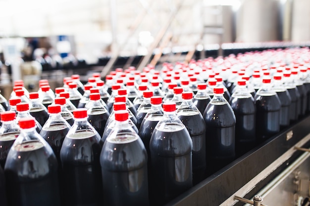 Bottling factory - Black juice bottling line for processing and bottling juice into bottles. Selective focus.