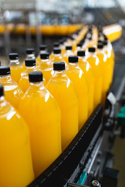 Bottling factory - Orange juice bottling line for processing and bottling juice into bottles. Selective focus.