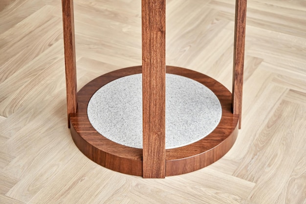 Bottom of coffee table made of veneer and solid walnut with acrylic detail on floor in room closeup