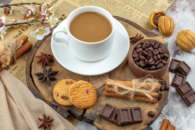 bottom view cup of coffee biscuits bowl with roasted coffee beans chocolate cinnamon sticks anises on wood board on table