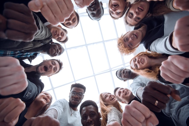 Bottom view  group of diverse young people joining their hands in a ring