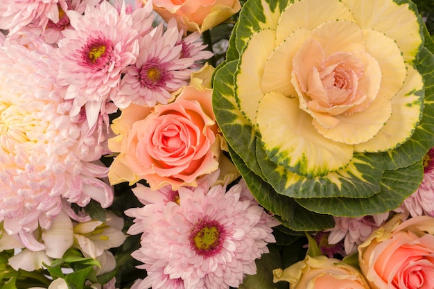 Bouquet of beautiful flowers with pink roses brassica flower chrysanthemum and freesia flower as a background