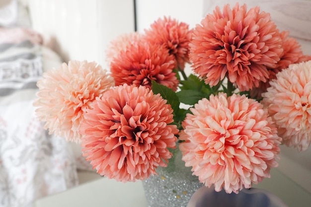 A bouquet of beautiful pink artificial flowers on a white table in the bedroom Interior design Romantic morning Women's bedroom interior decoration Bouquet in a vase