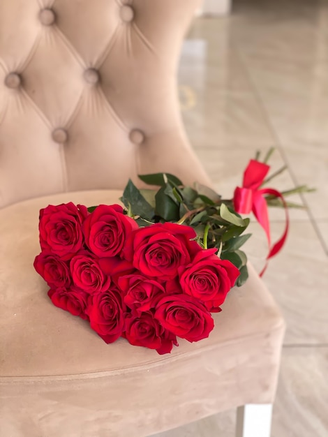 Bouquet of beautiful red roses for a gift to a girl, gorgeous flowers lie on a chair in a flower shop