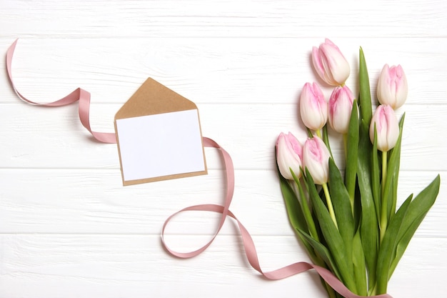 A bouquet of beautiful tulips and a gift on a wooden background top view. Mother's Day Background, International Women's Day. Holiday, give a gift. High quality photo