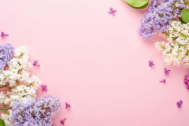 Bouquet of beautiful white and purple lilac on pink background. Top view. Festive greeting card with peony for weddings, happy womens day, Valentines and Mothers day.