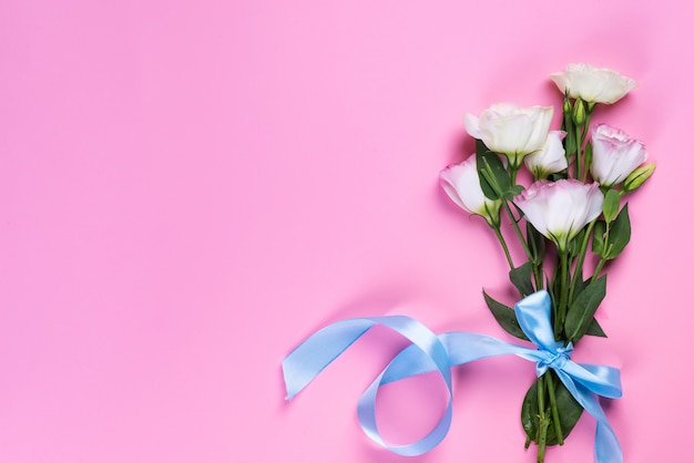 Bouquet blooming pink eustoma on pink background, flat lay. Valentines day, birthday, mother or wedding greeting card