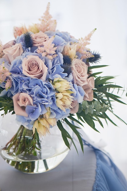 Bouquet of the bride with a powdery rose and blue hydrangeaWedding floristry