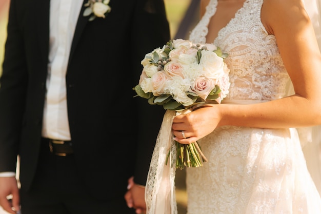 Bouquet in brides hands groom with his wife mid celection