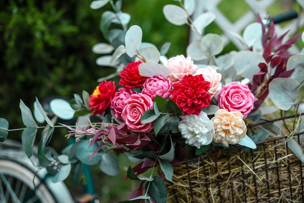 Bouquet of bright colourful colours made from soap in basket of old vintage bike in summer garden