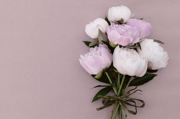 Bouquet of delicate pink and white peonies on a vintage background