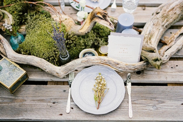 Bouquet of dried flowers on a plate near the wedding invitation on the table Top view