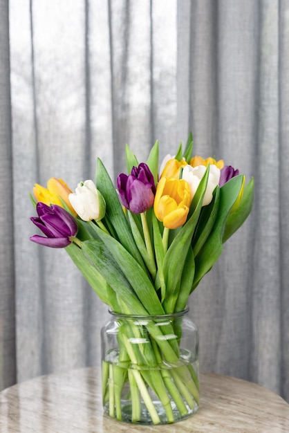 Bouquet of fresh bright colorful tulips on a side table