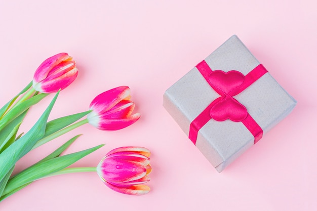 Bouquet of fresh red tulip flowers and giftbox on white background. Gift for a woman on holiday International Women's Day, Mother's, Valentine's day, birthday, anniversary and other events.