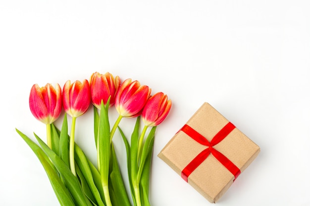 Bouquet of fresh red tulip flowers and giftbox on white