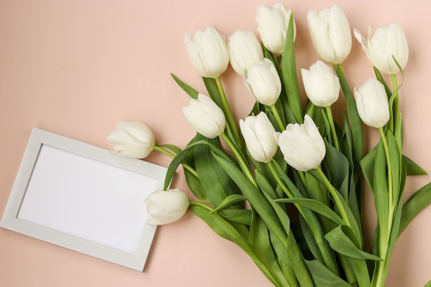 Bouquet of fresh spring white tulips lies on a light pastel background, Top view