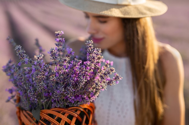 Bouquet of lavender in a basket on the background of a young beautiful woman