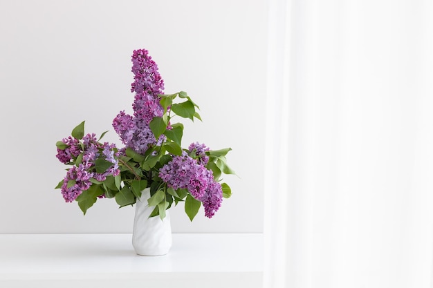 a bouquet of lilac in a white vase