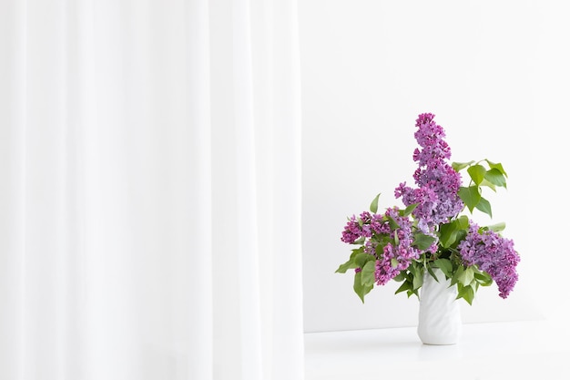 a bouquet of lilac in a white vase