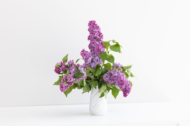 a bouquet of lilac in a white vase