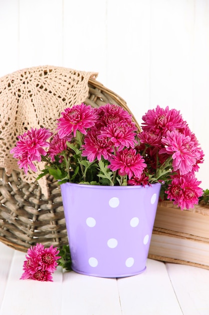 Bouquet of pink chrysanthemum in bucket on white wooden background