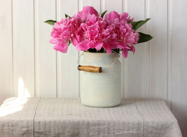 Photo bouquet of pink peonies on the table.