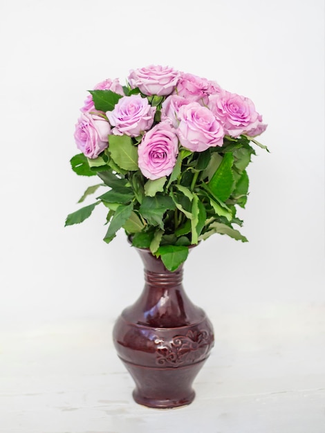 Bouquet of pink roses in a vase on a white background