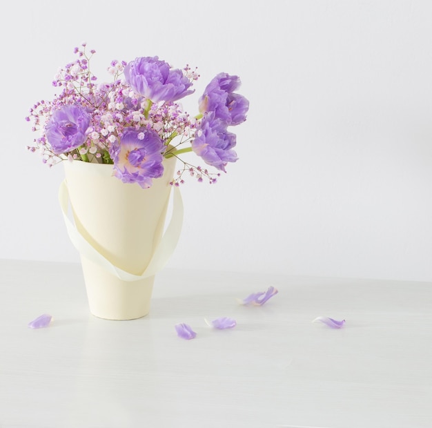 Bouquet of pink tulips and gypsophila on   white table