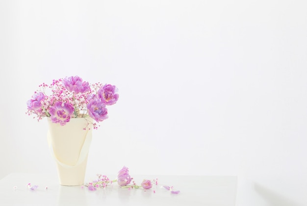 Bouquet of pink tulips and gypsophila on white table